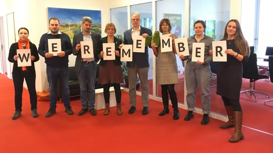 Acht Abgeordnete der Fraktion halten die Botschaft We remember – wir erinnern uns.